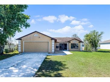 Charming tan home featuring a two-car garage and well-manicured front lawn, creating a welcoming curb appeal at 3141 Wainwright St, Deltona, FL 32738