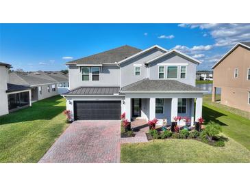 Charming two-story home with well-manicured lawn, brick driveway, and front porch at 5645 Camilla St, St Cloud, FL 34771