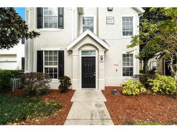 Inviting front entrance with a black door, well-maintained landscaping, and a clear address display at 9117 Lee Vista Blvd # 603, Orlando, FL 32829
