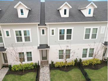 Charming townhouse features three stories, grey siding, nice landscaping, and a welcoming front entrance at 936 Wild Date Ln, Lake Mary, FL 32746