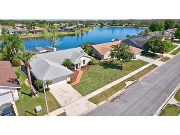 Beautiful single-Gathering home with attached garage, lush lawn and landscaping near a lake at 14772 Eagles Crossing Dr, Orlando, FL 32837