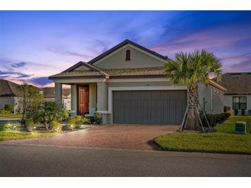 Charming single-story home featuring a brick driveway, two-car garage, and beautiful landscaping at 188 Olympus Way, Kissimmee, FL 34759