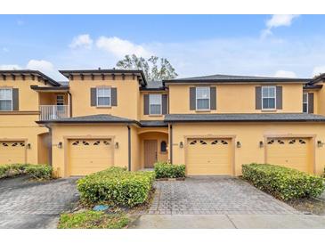 Inviting townhome featuring a two-car garage and well-maintained landscaping at 2040 Retreat View Cir, Sanford, FL 32771