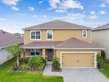 Lovely two-story home with a well-maintained lawn and an attached two-car garage at 211 Lazio Cir, Debary, FL 32713