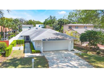 Charming single-story home with a well-manicured lawn, lush landscaping, and a spacious two-car garage at 250 Cortland Ave, Winter Park, FL 32789