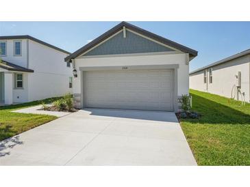 Attached two-car garage featuring a concrete driveway and neutral color palette at 2514 Linda Knoll Ln, Bartow, FL 33830