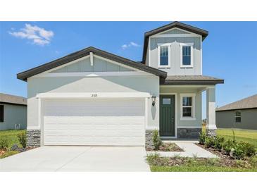 Charming two-story home featuring a two-car garage, light-colored exterior, and a well-manicured lawn at 2515 Linda Knoll Ln, Bartow, FL 33830