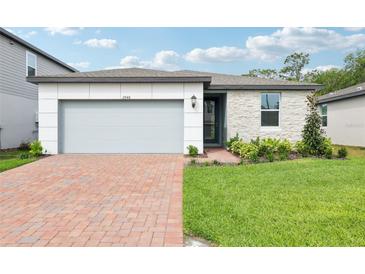 Charming single-story home featuring a brick driveway, stone accents, and well-maintained landscaping at 2948 Wild Olive Dr, St Cloud, FL 34772