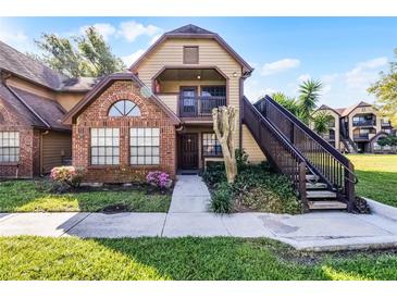 Charming two-story townhome featuring brick accents, a balcony, and inviting entrance with landscaped yard at 366 Waterside Dr # 102, Altamonte Springs, FL 32701