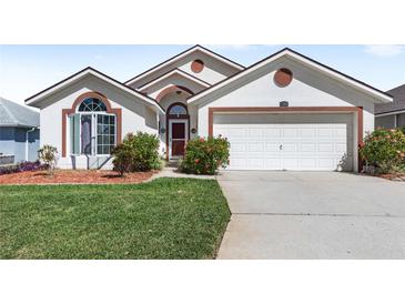 Charming single-story home featuring a well-manicured lawn and an attached two-car garage at 130 Hillside Dr, Davenport, FL 33897