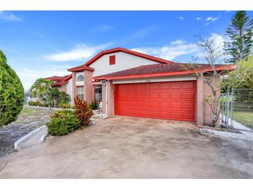 Charming two-story home featuring a vibrant red garage door and brick accents at 13542 Texas Woods Cir, Orlando, FL 32824