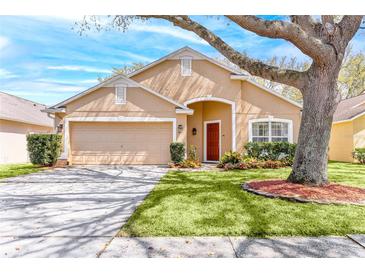 Charming single-story home with a well-manicured lawn, mature tree, and inviting red door at 2109 Carpathian Dr, Apopka, FL 32712