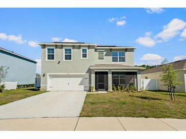 Charming two-story home featuring a spacious two-car garage and a welcoming screened-in porch at 2736 Dumont Ln, Tavares, FL 32778