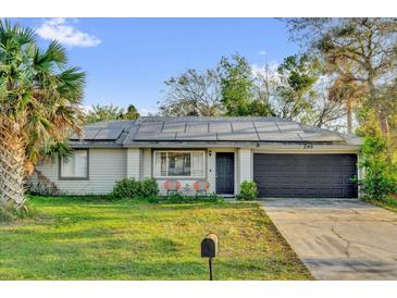 Charming single-story home with solar panels, a well-manicured lawn, and a two-car garage at 295 Garland St, Deltona, FL 32725