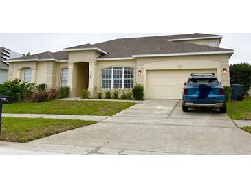 Charming single-story home featuring a well-manicured lawn and an attached two-car garage at 334 Prestwick Dr, Davenport, FL 33897