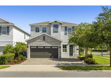 Beautiful two-story home featuring stone accents, a two-car garage, and a well-manicured lawn at 7641 Fairfax Dr, Kissimmee, FL 34747