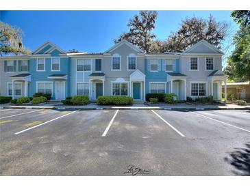 Charming townhome exterior featuring colorful facades, well-manicured landscaping, and convenient parking spaces at 1178 Vineland Pl, Lake Mary, FL 32746