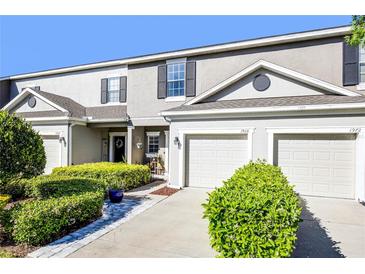 Charming townhome with manicured landscaping and attached garage, offering curb appeal at 1968 Compass Flower Way, Ocoee, FL 34761