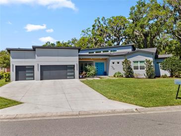 Stunning one-story home featuring a sleek design, modern garage doors, and a vibrant blue front door at 2058 Washington Ave, Sanford, FL 32771