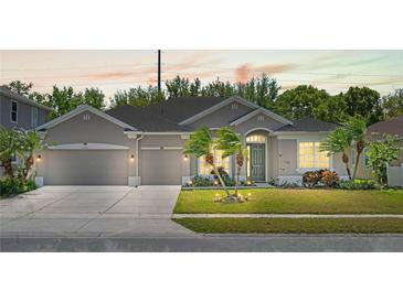 Charming single-story home with a well-manicured lawn, three-car garage and complemented by swaying palm trees at 2501 Hinsdale Dr, Kissimmee, FL 34741