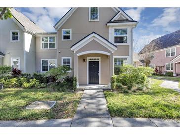 Charming front door entrance with a well-manicured lawn and inviting walkway to the home at 3398 Greenwich Village Blvd # 104, Orlando, FL 32835