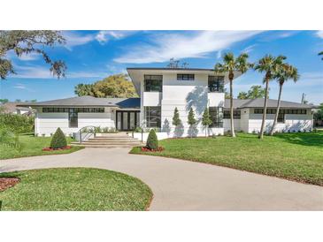 Modern white home features a striking architectural design, beautiful landscaping, and a circular driveway at 409 W 2Nd Ave, Windermere, FL 34786