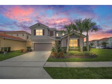 Beautiful two-story home with tropical landscaping, gray exterior, and a two-car garage, set against a colorful sky at 6049 Broad Oak Dr, Davenport, FL 33837