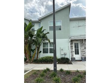 Two-story townhome showcases modern architecture, lush landscaping, and a welcoming front door at 8008 Formosa Valley Pl, Kissimmee, FL 34747