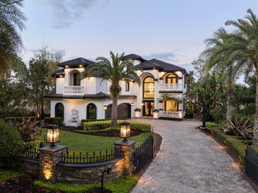 Stunning two-story home featuring manicured landscaping, stone accents, and a circular driveway at 801 W 2Nd Ave, Windermere, FL 34786