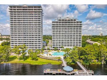 Stunning view of two high-rise buildings and waterfront amenities including a pool and dock with lake access at 13427 Blue Heron Beach Dr # 103, Orlando, FL 32821