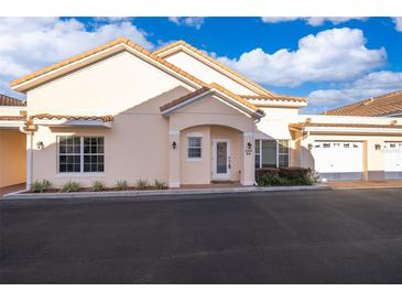 Inviting villa showcasing a tile roof, attached garage, and neatly trimmed front yard landscaping at 204 David Walker Dr # A-4, Tavares, FL 32778