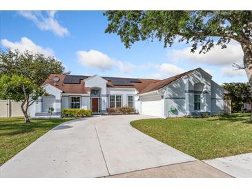 Charming single-story home features a well-manicured lawn, a concrete driveway, and solar panels for energy efficiency at 2821 Lone Feather Dr, Orlando, FL 32837