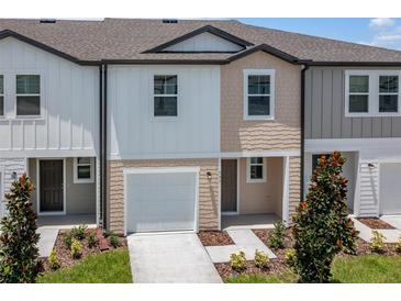 Charming townhome showcasing a well-manicured lawn and a convenient one-car garage at 5926 Piney Shrub Pl, St Cloud, FL 34771