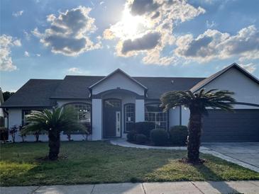 Charming single-story home featuring a well-manicured lawn and attractive landscaping at 12546 Britwell Ct, Orlando, FL 32837