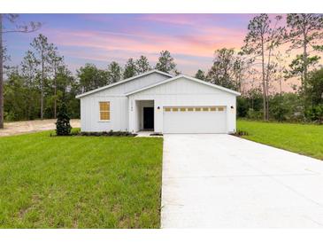 Charming one-story home featuring a well-manicured lawn, attached two car garage, and modern curb appeal at 13457 Sw 53Rd St, Ocala, FL 34481