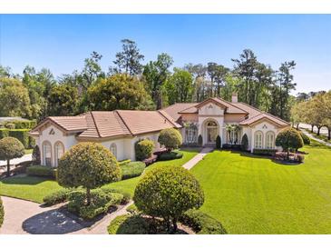 Stunning exterior with lush lawn, manicured landscaping, and a beautiful tile roof at 401 Timberwalk Ln, Lake Mary, FL 32746