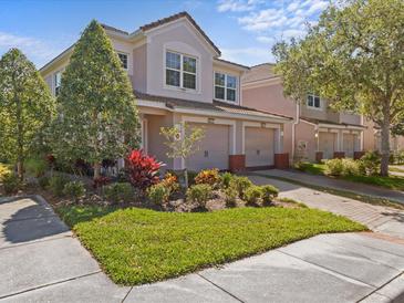 Beautiful two-story home with well-manicured lawn, vibrant landscaping, and an attached two-car garage at 8312 Fontera Dr, Davenport, FL 33896