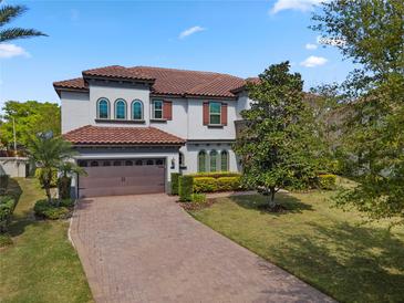 Beautiful two-story home with a tile roof, brick driveway, and lush green lawn at 8531 Geddes Loop, Orlando, FL 32836