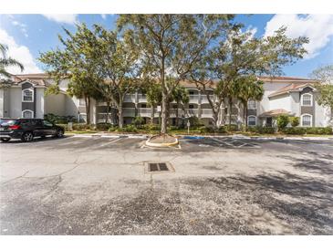 Multi-story condo building with ample parking and mature shade trees in a well-maintained community at 13929 Fairway Island Dr # 825, Orlando, FL 32837