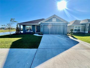 Charming single-Gathering home featuring manicured lawn, water view, and a well-lit driveway at 2107 Cartgate Ln, Winter Haven, FL 33884