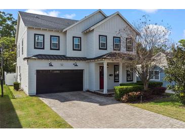 Charming two-story home boasts a brick driveway, attached garage, and manicured landscaping at 2108 Delaney Ave, Orlando, FL 32806