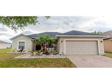 Charming single-story home with a well-manicured lawn, mature landscaping, and a two-car garage at 2904 Sweetspire Cir, Kissimmee, FL 34746