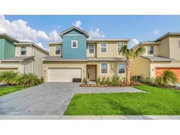 Inviting two-story home featuring a well-maintained front yard and a two-car garage at 4405 Durga Ln, Kissimmee, FL 34746