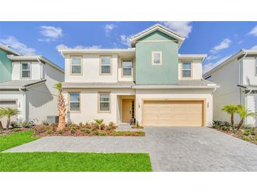 Two-story home showcases a two-car garage, manicured landscaping, and a charming front entrance at 4421 Durga Ln, Kissimmee, FL 34746