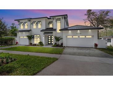 Striking modern home with a three-car garage, pristine landscaping, and a sleek, flat roof design at 640 Old Horatio Ave, Maitland, FL 32751