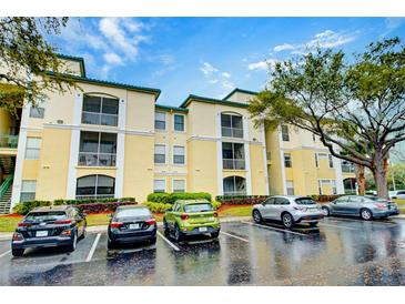 View of the property complex with ample parking and landscaping at 8819 Dunes Ct # 208, Kissimmee, FL 34747