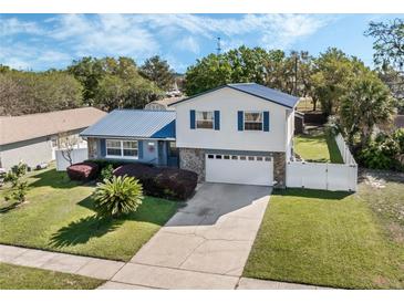 Charming home with a blue metal roof, stone accents, and well-maintained landscaping at 1189 Lazy Hollow Pl, Winter Park, FL 32792