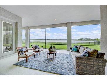 Screened lanai with comfortable seating and a view of the water at 16689 Broadwater Ave, Winter Garden, FL 34787