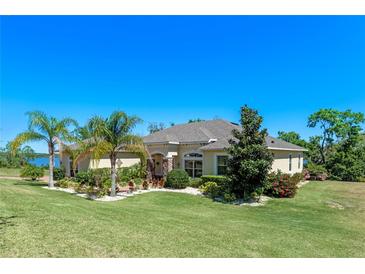 Beautiful single-story home featuring manicured landscaping, palm trees, and a well-maintained lawn at 16752 Caravaggio Loop, Montverde, FL 34756
