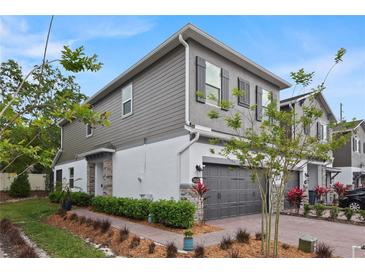 Charming two-story home features stone accents, gray siding and shutters, and a well-manicured front yard at 3173 Riverboat Way, Oviedo, FL 32765